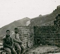 Men seat at the Great Wall of China, c.1920 