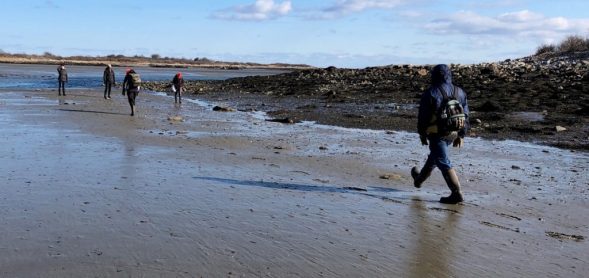 Archaeologist stepping off distance between rocks